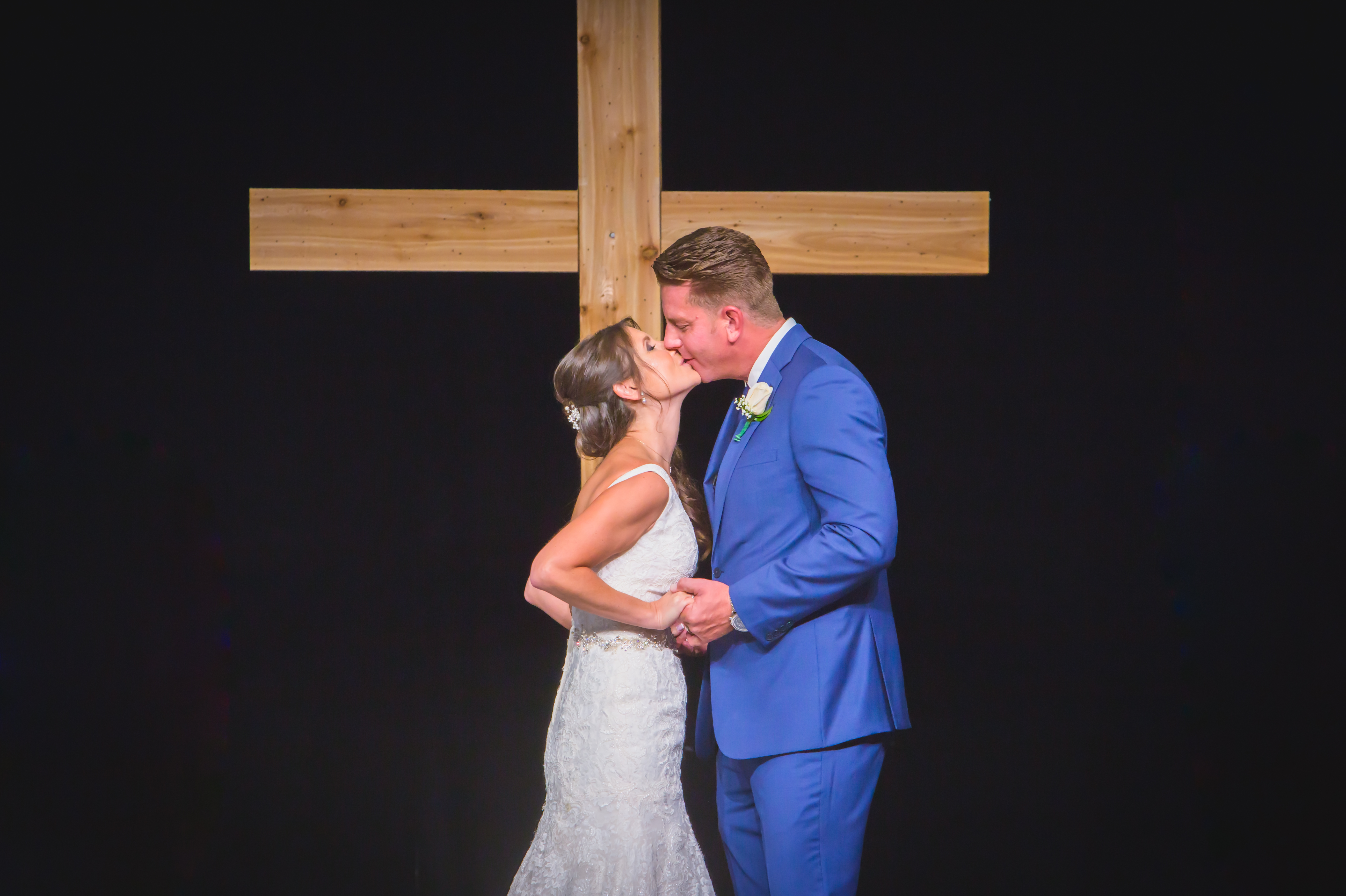 Bride and groom first kiss after being pronounced man and wife during their wedding at the Christ Fellowship Church in Palm Beach Gardens, Florida. Photography by Palm Beach Florida's best Wedding Photography Studio Couture Bridal Photography Alfredo Valentine